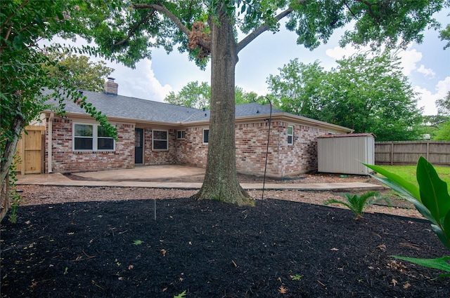 12706 Westleigh Dr, Houston, TX 77077 - rear view of property featuring a patio, brick siding, a storage unit, and a chimney