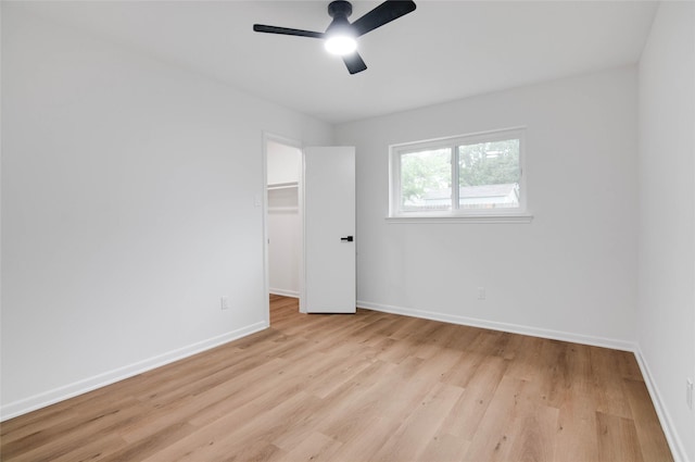 12706 Westleigh Dr, Houston, TX 77077 - unfurnished bedroom with light wood finished floors, ceiling fan, a walk in closet, and a closet