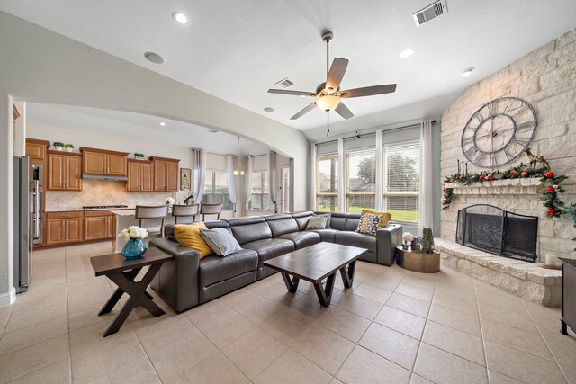 3822 Moreland Branch Ln, Katy, TX 77493 - living room featuring a ceiling fan, a fireplace, light tile patterned floors, arched walkways, and recessed lighting