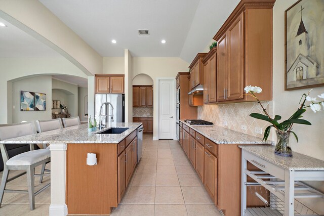 3822 Moreland Branch Ln, Katy, TX 77493 - kitchen with brown cabinets, stainless steel appliances, a kitchen bar, and recessed lighting