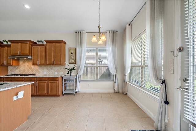 3822 Moreland Branch Ln, Katy, TX 77493 - kitchen with brown cabinets, a chandelier, plenty of natural light, and recessed lighting