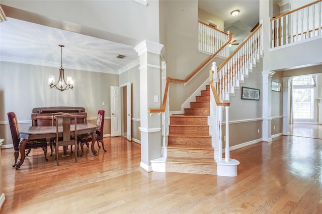 3718 W Pine Brook Way, Houston, TX 77059 - dining area with wood finished floors, stairs, a chandelier, ornate columns, and ornamental molding