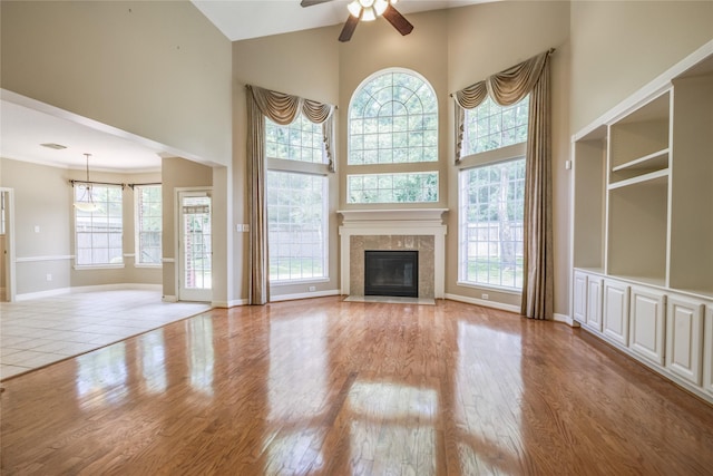 3718 W Pine Brook Way, Houston, TX 77059 - unfurnished living room with a towering ceiling, ceiling fan, wood finished floors, and a tile fireplace