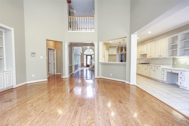 3718 W Pine Brook Way, Houston, TX 77059 - unfurnished living room with a high ceiling, light wood-type flooring, and built in features