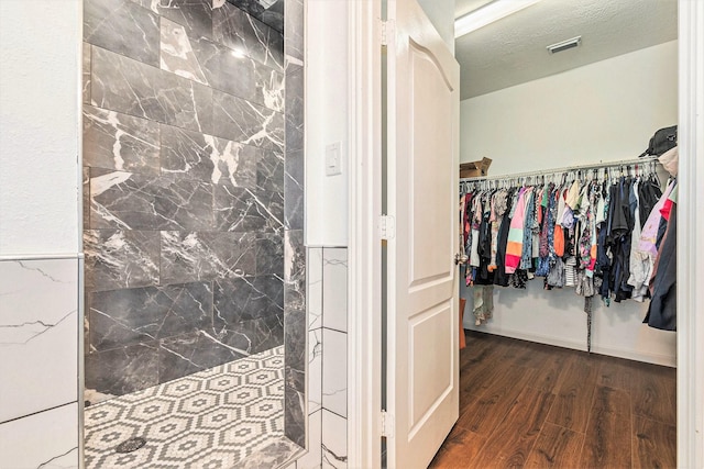 30110 Saw Oaks, Magnolia, TX 77355 - bathroom featuring wood finished floors, a tile shower, and a spacious closet