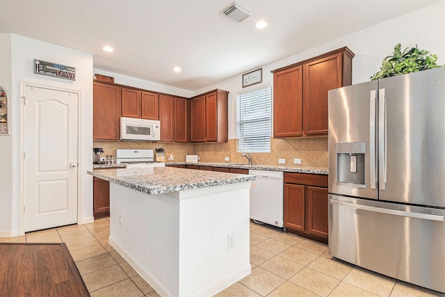30110 Saw Oaks, Magnolia, TX 77355 - kitchen featuring white appliances, light tile patterned floors, decorative backsplash, a kitchen island, and recessed lighting