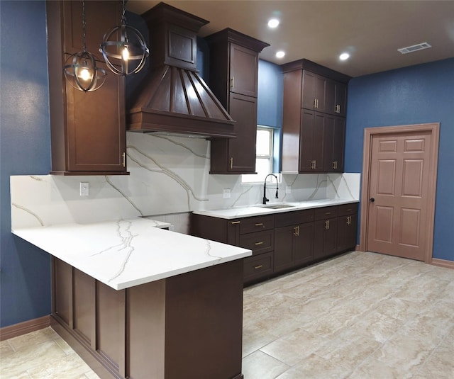 13326 Joliet St, Houston, TX 77015 - kitchen with custom exhaust hood, decorative backsplash, light stone counters, a peninsula, and dark brown cabinets