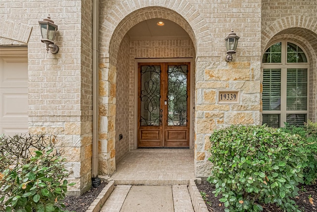 19339 Oxford Haven Dr, Cypress, TX 77433 - view of exterior entry featuring stone siding, french doors, and brick siding