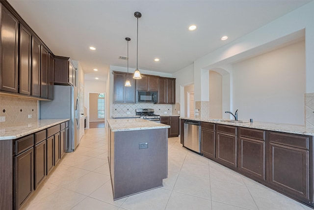 19339 Oxford Haven Dr, Cypress, TX 77433 - kitchen featuring stainless steel appliances, dark brown cabinetry, tasteful backsplash, a kitchen island, and recessed lighting