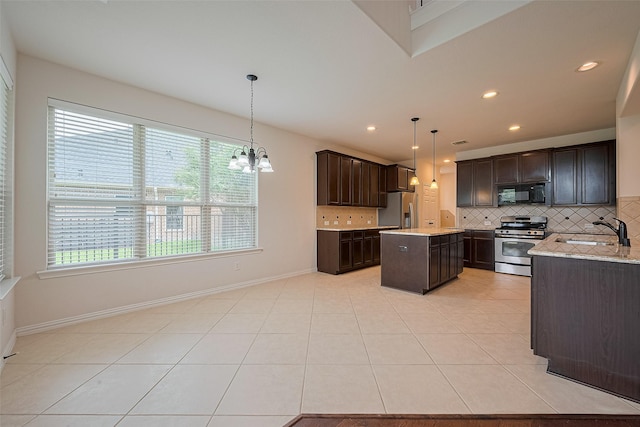 19339 Oxford Haven Dr, Cypress, TX 77433 - kitchen with stainless steel appliances, tasteful backsplash, dark brown cabinetry, a center island, and a chandelier