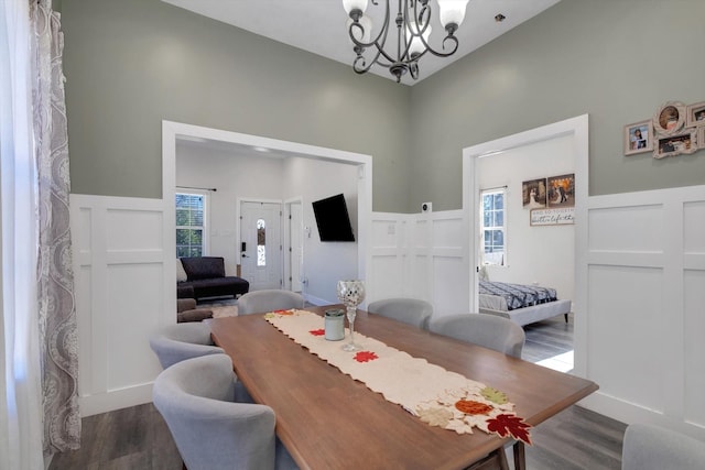 610 S Railroad Ave, Shepherd, TX 77371 - dining room with wood finished floors, a chandelier, a wainscoted wall, healthy amount of natural light, and a high ceiling