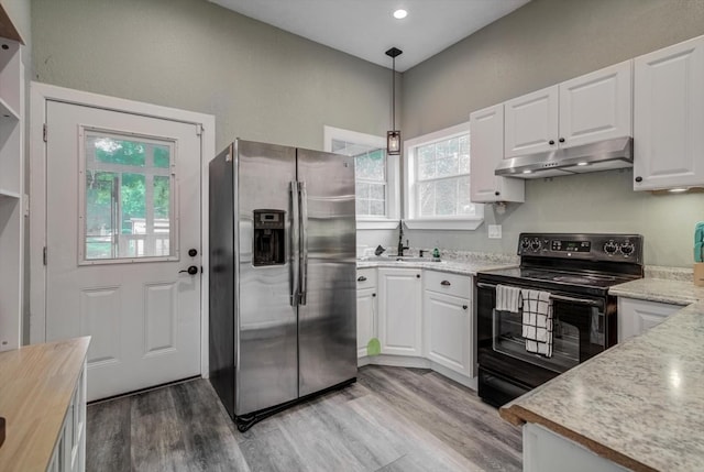 610 S Railroad Ave, Shepherd, TX 77371 - kitchen with stainless steel fridge, under cabinet range hood, black electric range oven, white cabinetry, and light wood-style flooring