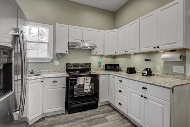610 S Railroad Ave, Shepherd, TX 77371 - kitchen featuring black appliances, under cabinet range hood, white cabinets, light wood finished floors, and light stone counters