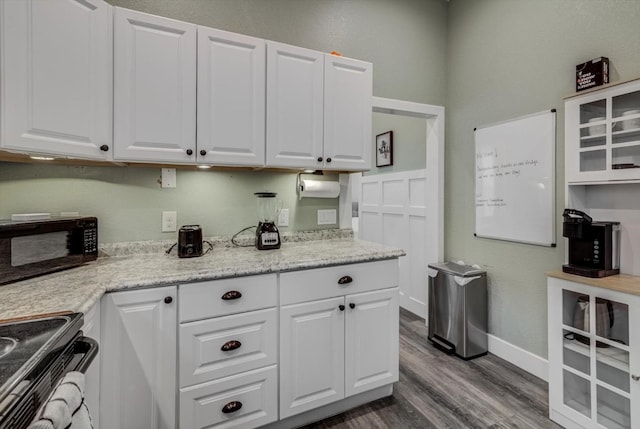 610 S Railroad Ave, Shepherd, TX 77371 - kitchen featuring electric range, black microwave, dark wood-type flooring, white cabinets, and glass insert cabinets