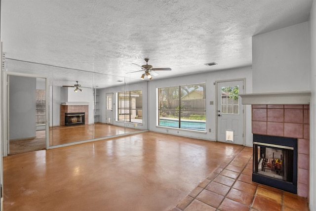 14202 Double Pine Dr, Houston, TX 77015 - unfurnished living room featuring a tile fireplace, a ceiling fan, and a textured ceiling
