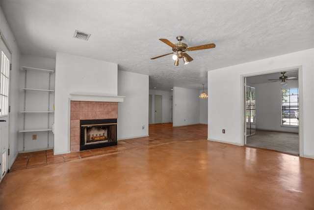 14202 Double Pine Dr, Houston, TX 77015 - unfurnished living room featuring ceiling fan, a tile fireplace, and a textured ceiling
