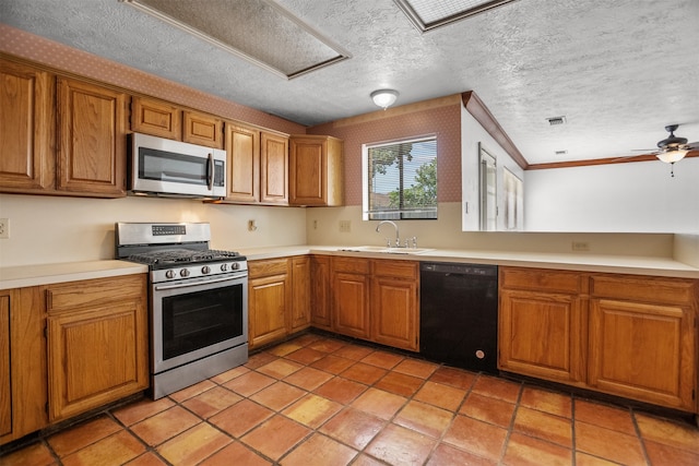 14202 Double Pine Dr, Houston, TX 77015 - kitchen featuring appliances with stainless steel finishes, brown cabinetry, light countertops, a textured ceiling, and a ceiling fan