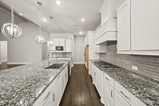 10519 Lantana Pass, Missouri City, TX 77459 - kitchen featuring stainless steel appliances, white cabinetry, dark stone countertops, dark wood-style flooring, and decorative backsplash