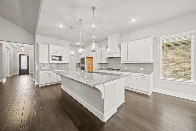 10519 Lantana Pass, Missouri City, TX 77459 - kitchen featuring built in microwave, a kitchen island with sink, tasteful backsplash, white cabinets, and recessed lighting