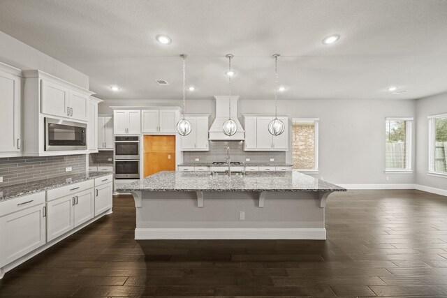 10519 Lantana Pass, Missouri City, TX 77459 - kitchen featuring appliances with stainless steel finishes, custom exhaust hood, recessed lighting, backsplash, and white cabinets