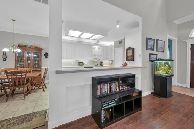 4723 Cashel Castle Dr, Houston, TX 77069 - kitchen with wood finished floors, white cabinets, and a peninsula