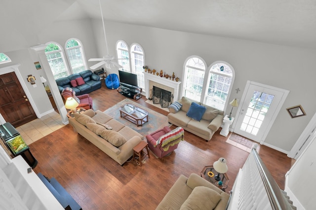 4723 Cashel Castle Dr, Houston, TX 77069 - living area featuring high vaulted ceiling, ceiling fan, healthy amount of natural light, a tile fireplace, and wood finished floors