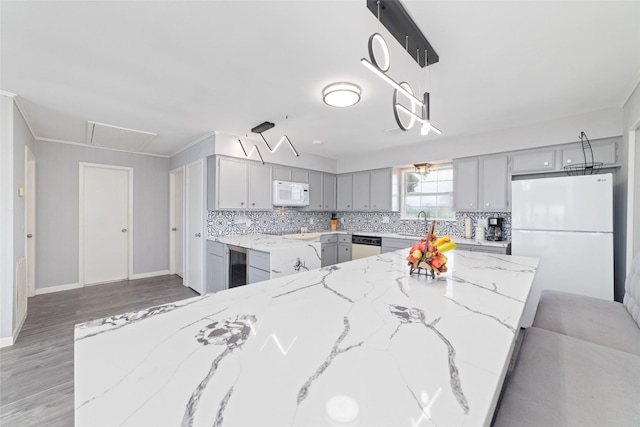 610 Seashell Dr, Freeport, TX 77541 - kitchen with white appliances, gray cabinets, wine cooler, tasteful backsplash, and light wood-type flooring