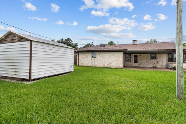 14115 Lantern Ln, Houston, TX 77015 - back of house with a patio, a yard, brick siding, a storage unit, and a chimney