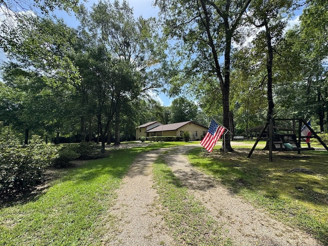 147 County Road 4772, Warren, TX 77664 - view of dirt / gravel driveway with view of wooded area