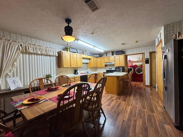 147 County Road 4772, Warren, TX 77664 - dining space with wallpapered walls, washer and clothes dryer, dark wood-type flooring, and a textured ceiling