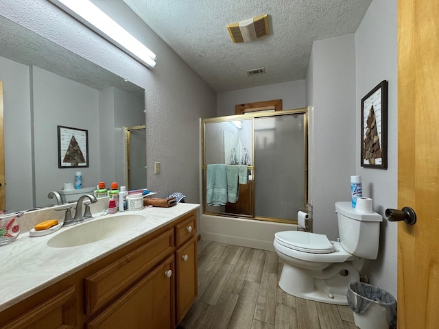 147 County Road 4772, Warren, TX 77664 - full bath with a textured ceiling, wood finished floors, vanity, and combined bath / shower with glass door
