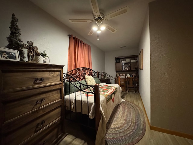147 County Road 4772, Warren, TX 77664 - bedroom featuring wood finished floors, a textured wall, and ceiling fan