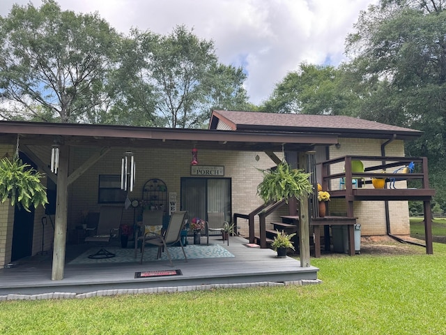 147 County Road 4772, Warren, TX 77664 - back of house featuring brick siding, a lawn, and a deck
