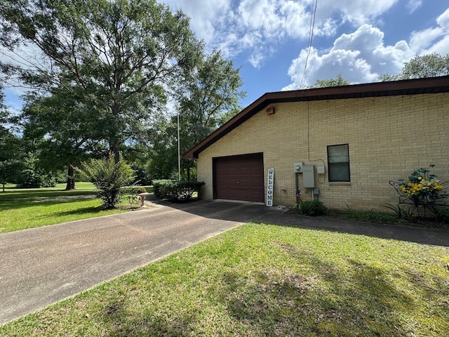 147 County Road 4772, Warren, TX 77664 - view of side of property featuring brick siding, concrete driveway, and a yard