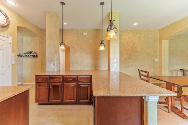 18419 W Willow Oak Bend Dr, Cypress, TX 77433 - kitchen with light tile patterned flooring, a peninsula, light stone counters, and pendant lighting