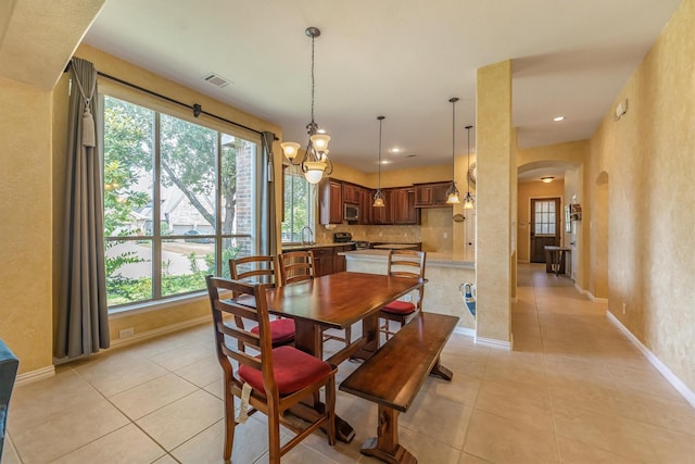 18419 W Willow Oak Bend Dr, Cypress, TX 77433 - dining area featuring arched walkways, plenty of natural light, light tile patterned floors, a textured wall, and recessed lighting