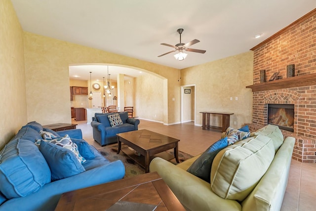 18419 W Willow Oak Bend Dr, Cypress, TX 77433 - living area with arched walkways, a ceiling fan, light tile patterned floors, and a fireplace