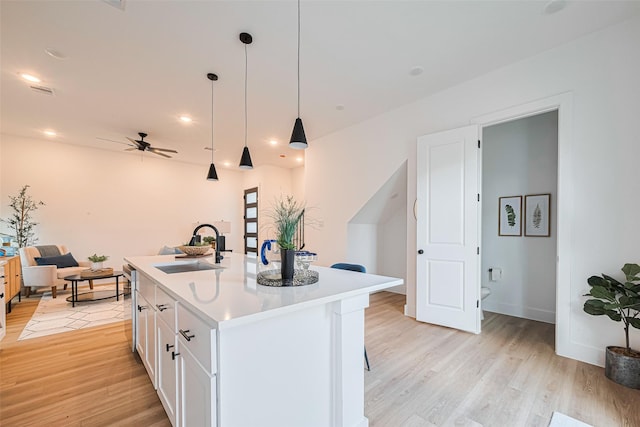 2710 Bostic St, Houston, TX 77093 - kitchen featuring ceiling fan, light wood-style floors, white cabinets, light countertops, and hanging light fixtures