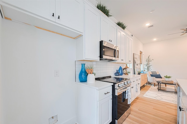 2710 Bostic St, Houston, TX 77093 - kitchen with stainless steel appliances, light wood-style floors, decorative backsplash, white cabinetry, and light countertops