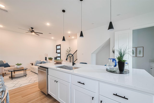 2710 Bostic St, Houston, TX 77093 - kitchen featuring stainless steel dishwasher, open floor plan, a ceiling fan, light wood-type flooring, and white cabinets