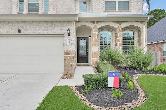 13310 Hidden Valley Dr, Montgomery, TX 77356 - view of exterior entry with a garage, concrete driveway, and brick siding