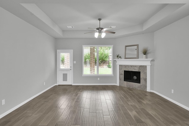 13310 Hidden Valley Dr, Montgomery, TX 77356 - unfurnished living room with a ceiling fan, dark wood-style flooring, a tray ceiling, and a tile fireplace