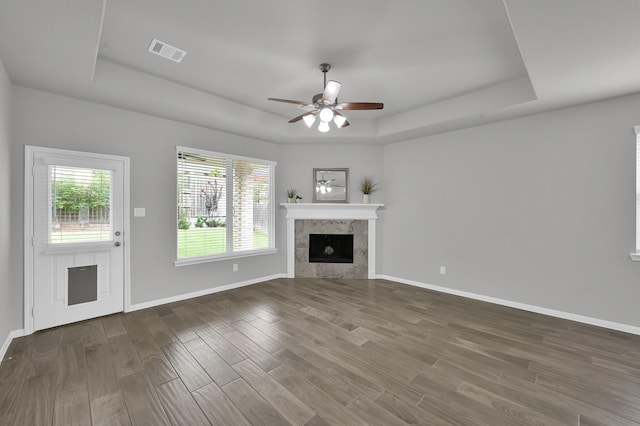 13310 Hidden Valley Dr, Montgomery, TX 77356 - unfurnished living room with a tray ceiling, a ceiling fan, dark wood finished floors, and a tiled fireplace