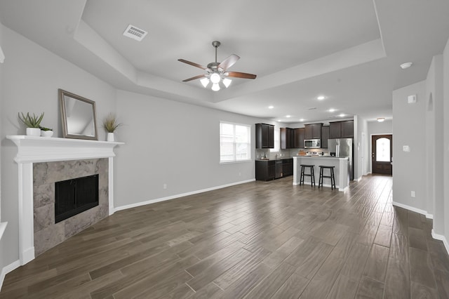13310 Hidden Valley Dr, Montgomery, TX 77356 - unfurnished living room with a raised ceiling, ceiling fan, dark wood finished floors, a fireplace, and recessed lighting