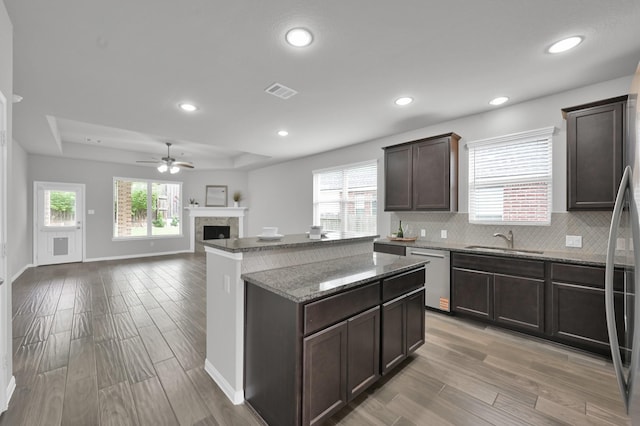 13310 Hidden Valley Dr, Montgomery, TX 77356 - kitchen featuring dishwasher, dark brown cabinets, light wood-style floors, a ceiling fan, and a center island