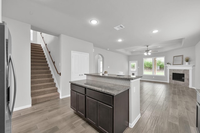 13310 Hidden Valley Dr, Montgomery, TX 77356 - kitchen featuring stainless steel refrigerator with ice dispenser, light wood-style flooring, a ceiling fan, a tray ceiling, and recessed lighting