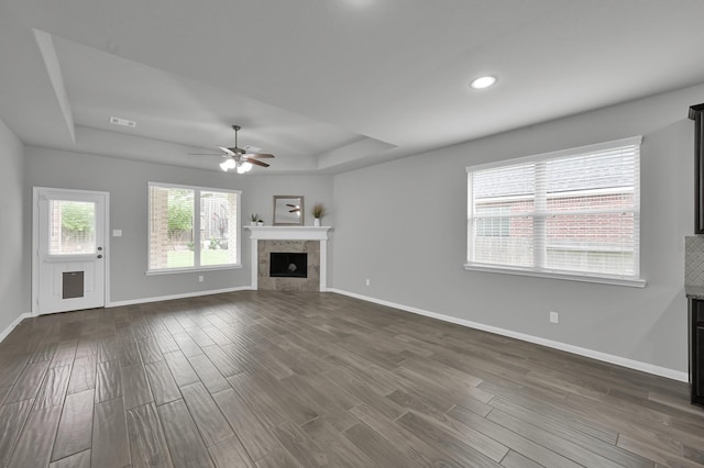 13310 Hidden Valley Dr, Montgomery, TX 77356 - unfurnished living room with a raised ceiling, a fireplace, dark wood-style flooring, a ceiling fan, and recessed lighting