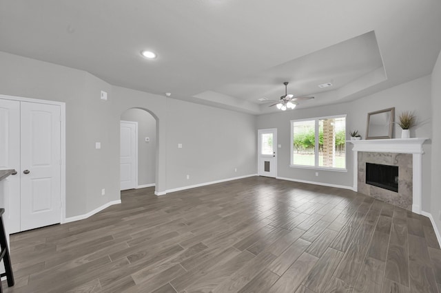 13310 Hidden Valley Dr, Montgomery, TX 77356 - unfurnished living room with a raised ceiling, arched walkways, ceiling fan, wood finished floors, and recessed lighting