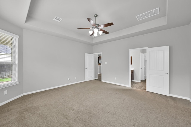 13310 Hidden Valley Dr, Montgomery, TX 77356 - unfurnished bedroom with a tray ceiling, carpet, ensuite bath, and ceiling fan