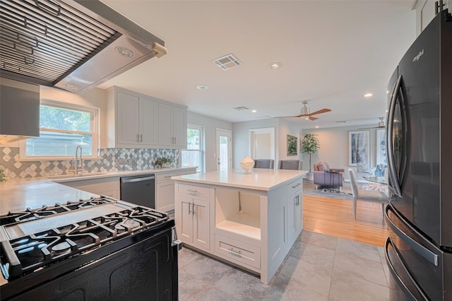 5123 Saxon Dr, Houston, TX 77092 - kitchen featuring stainless steel appliances, exhaust hood, light countertops, tasteful backsplash, and a ceiling fan